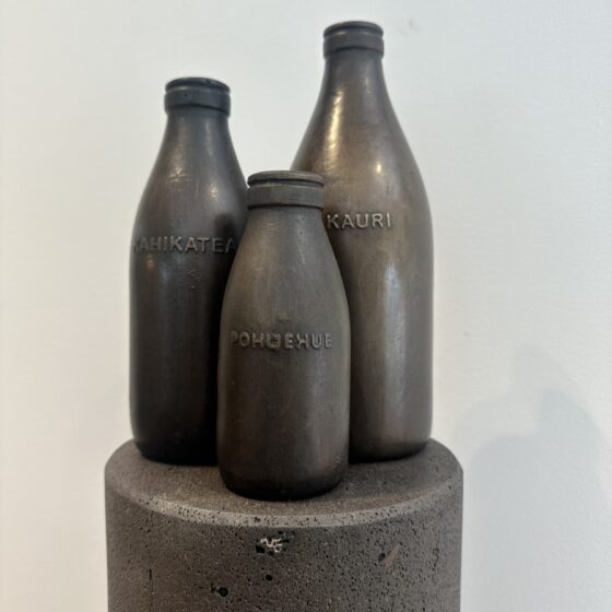 three bronze milk bottles