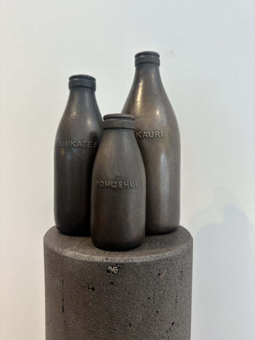 three bronze milk bottles