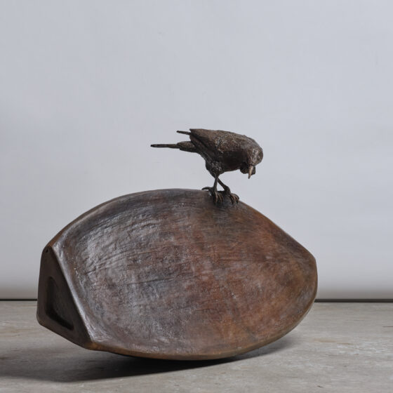 giant bronze seed with a tui perched on top
